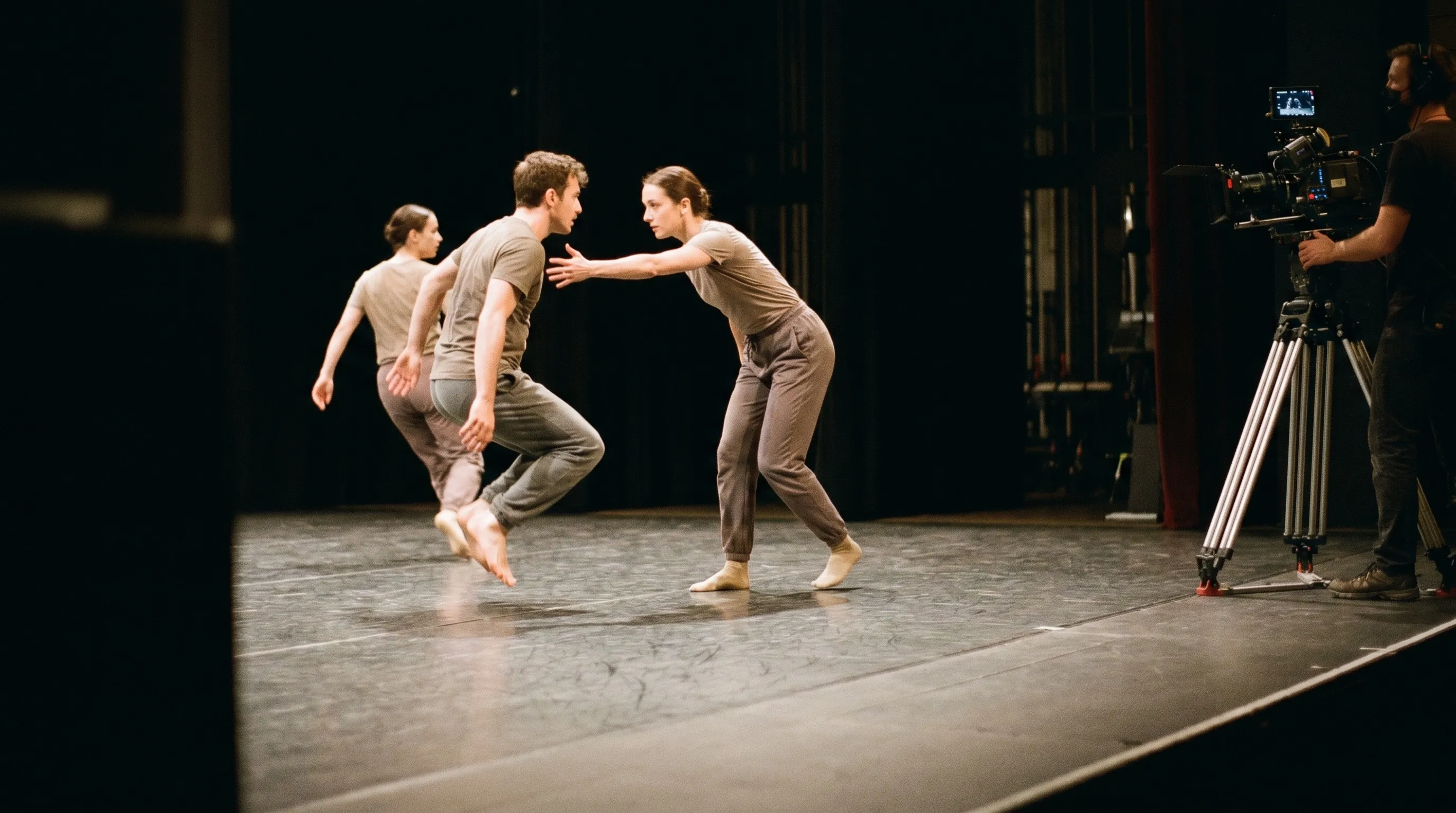 Spectacle de danse contemporaine sur scène filmé par une caméra discrète au bord du plateau